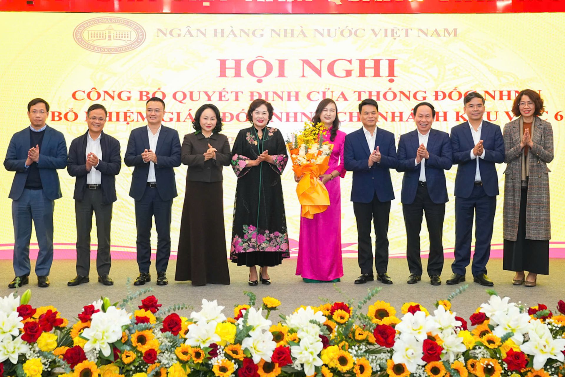 Lãnh đạo thành phố tặng hoa chúc mừng Giám đốc Ngân hàng Nhà nước chi nhánh Khu vực 6 Nguyễn Thị Dung.