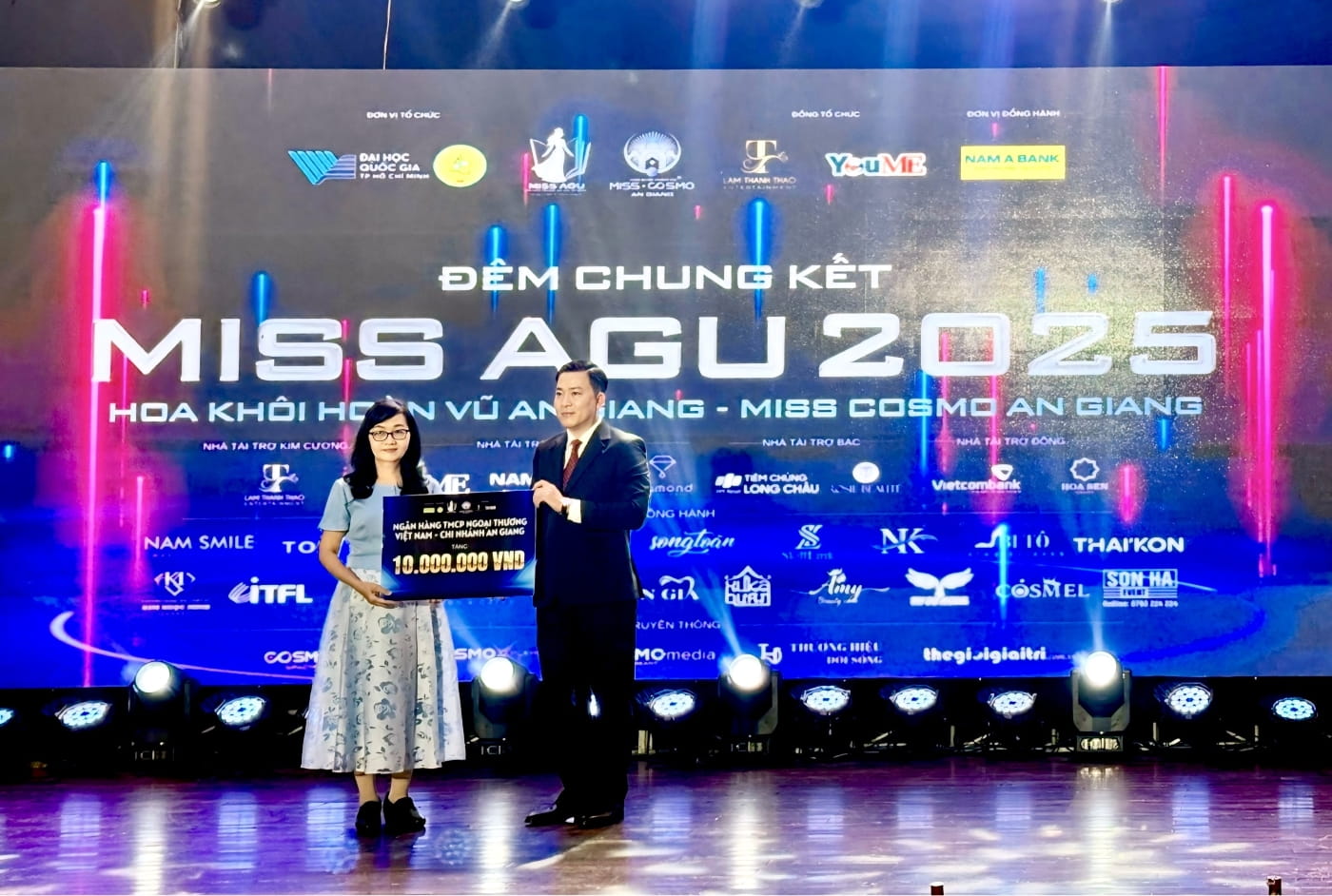 Bà Dương Thoại Uyên - Phó Giám đốc, Chủ tịch Công đoàn cơ sở Vietcombank An Giang trao biểu trưng số tiền tài trợ cho TS. Nguyễn Hữu Trí - Phó Hiệu trưởng Phụ trách Trường Đại học An Giang