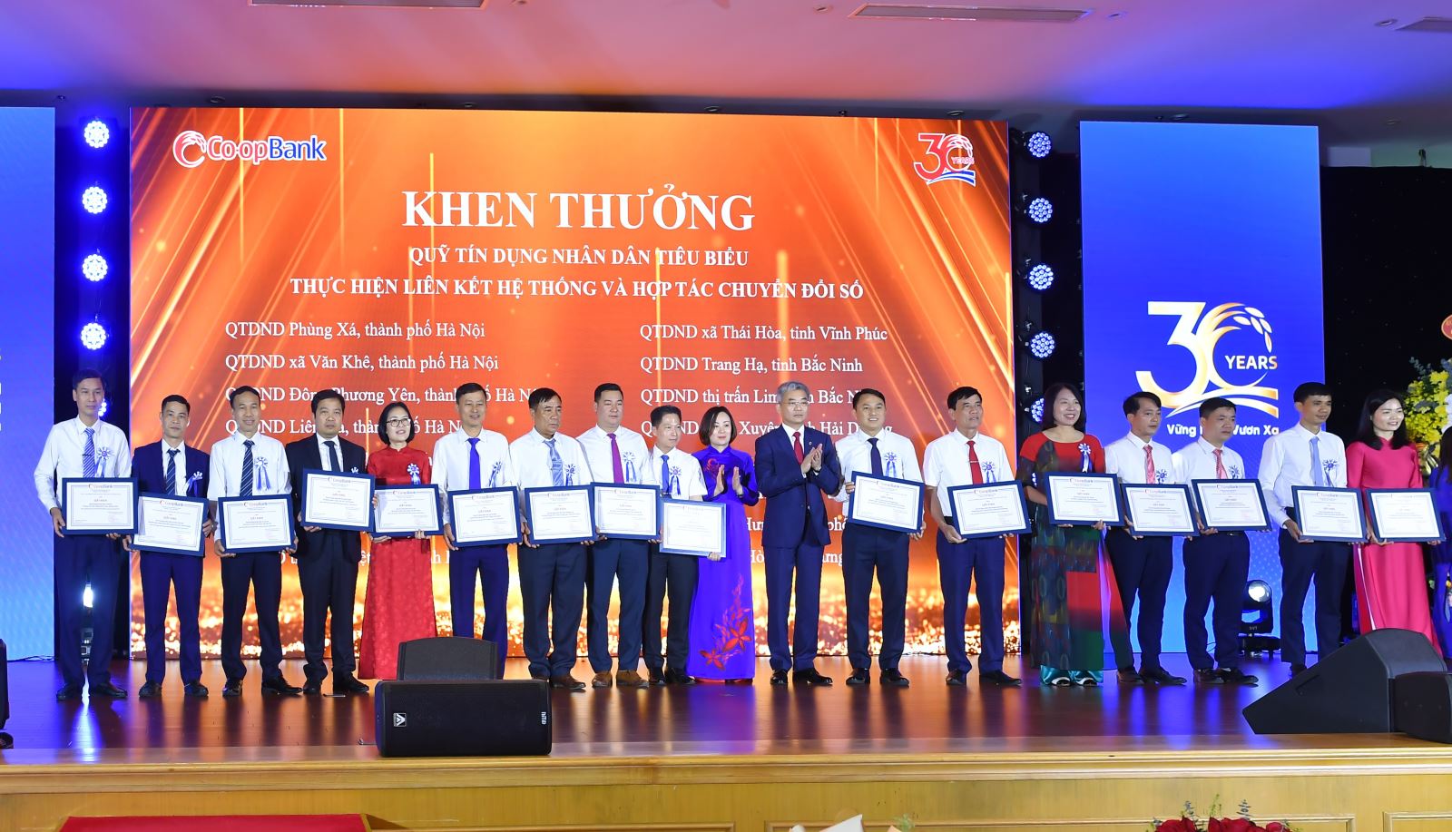 Ông Nguyễn Quốc Cường - Chủ tịch Hội đồng quản trị Co-opBank, bà Phạm Thị Hồng Minh - Tổng giám đốc Co-opBank trao vinh danh các QTDND thành viên thực hiện tốt mối liên kết hệ thống và hợp tác chuyển đổi số tại buổi lễ kỷ niệm 30 năm thành lập Co-opBank
