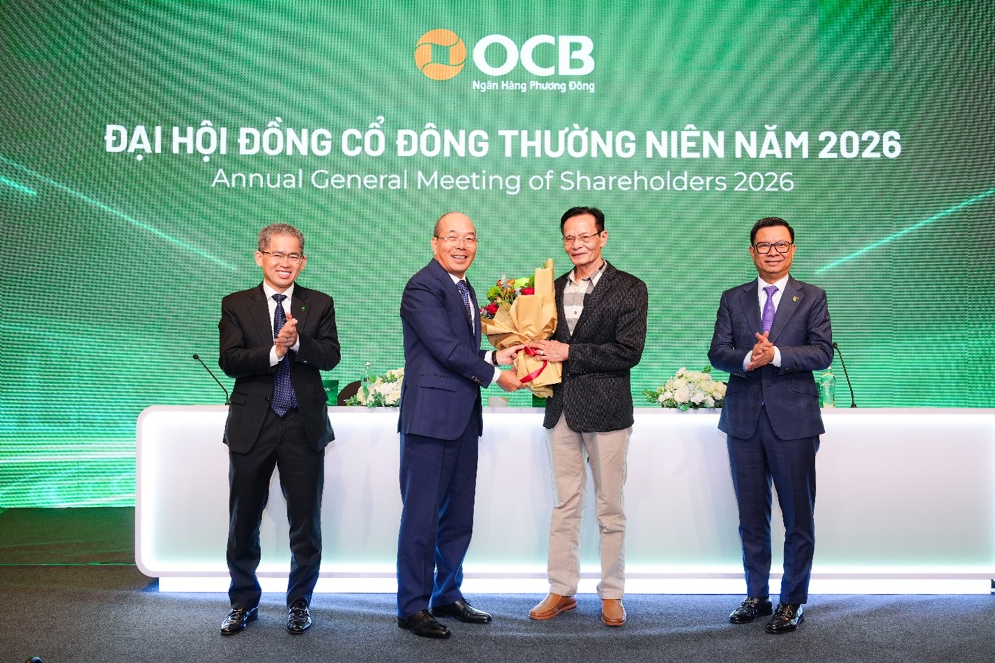 Tiến sĩ Lê Xuân Nghĩa nhận hoa chúc mừng từ Ông Trịnh Văn Tuấn, Chủ tịch HĐQT OCB