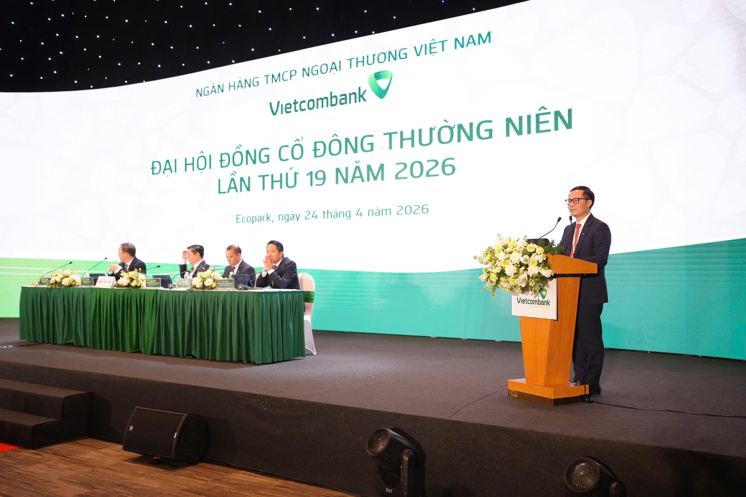 Ông Lê Hoàng Tùng - Phó Tổng Giám đốc Vietcombank trình bày Tờ trình về việc thông qua Báo cáo tài chính đã được kiểm toán và phương án phân phối lợi nhuận năm 2025, Tờ trình về mức thù lao đối với thành viên HĐQT và thành viên BKS của Vietcombank năm 2026