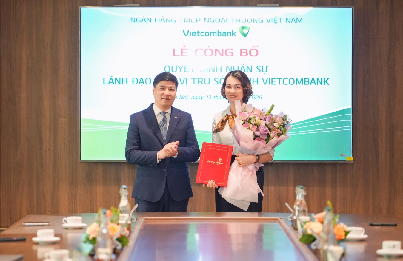 Ông Hồng Quang - Thành viên HĐQT kiêm Giám đốc Khối Nhân sự Vietcombank trao quyết định và tặng hoa chúc mừng bà Đoàn Song Ngân - tân Phó Giám đốc Trường Đào tạo và phát triển nguồn nhân lực TSC Vietcombank