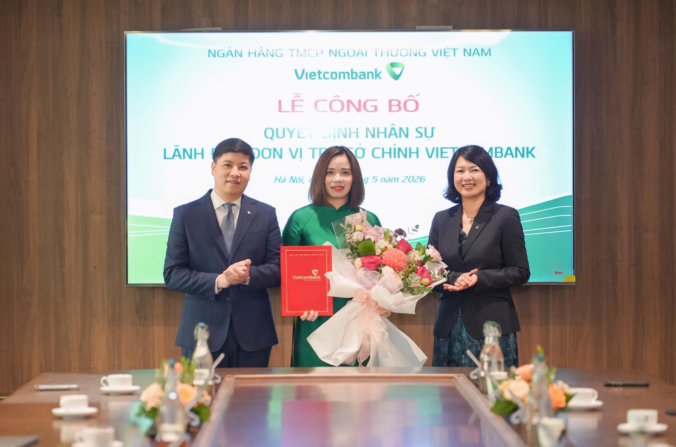Ông Hồng Quang - Thành viên HĐQT kiêm Giám đốc Khối Nhân sự Vietcombank (bên trái) trao quyết định và bà Nguyễn Thị Hồng Vân - Giám đốc Khối Pháp chế & Tuân thủ (bên phải) tặng hoa chúc mừng bà Phạm Vân Giang - tân Phó trưởng phòng Quản lý rủi ro thị trường TSC Vietcombank