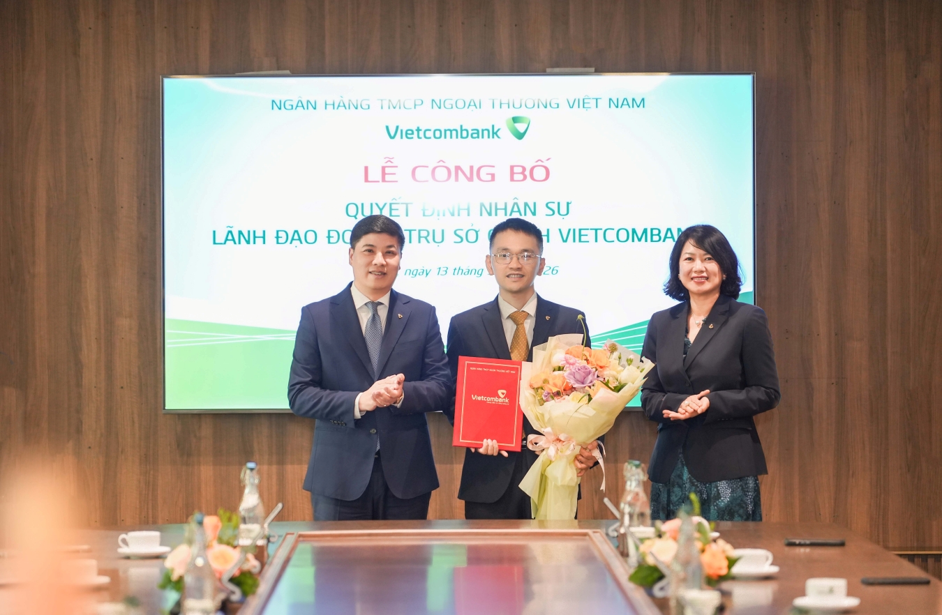 Ông Hồng Quang - Thành viên HĐQT kiêm Giám đốc Khối Nhân sự Vietcombank (bên trái) trao quyết định và bà Nguyễn Thị Hồng Vân - Giám đốc Khối Pháp chế & Tuân thủ (bên phải) tặng hoa chúc mừng ông Vương Minh Giang - tân Trưởng phòng Quản lý rủi ro tích hợp TSC Vietcombank
