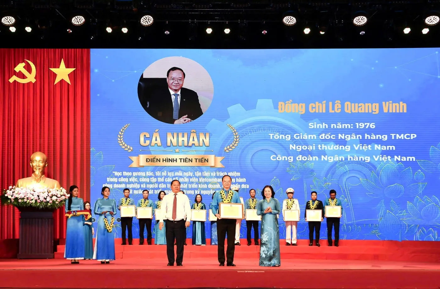 Đồng chí Nguyễn Phi Long - Ủy viên Ban chấp hành Trung ương Đảng, Phó Bí thư Thường trực Đảng ủy Mặt trận Tổ quốc các đoàn thể Trung ương, Phó Chủ tịch Ủy ban Trung ương Mặt trận Tổ quốc Việt Nam (bên trái) trao hoa chúc mừng và đồng chí Thái Thu Sương - Phó Chủ tịch thường trực Tổng Liên đoàn Lao động Việt Nam (bên phải) trao bằng khen cho đồng chí Lê Quang Vinh