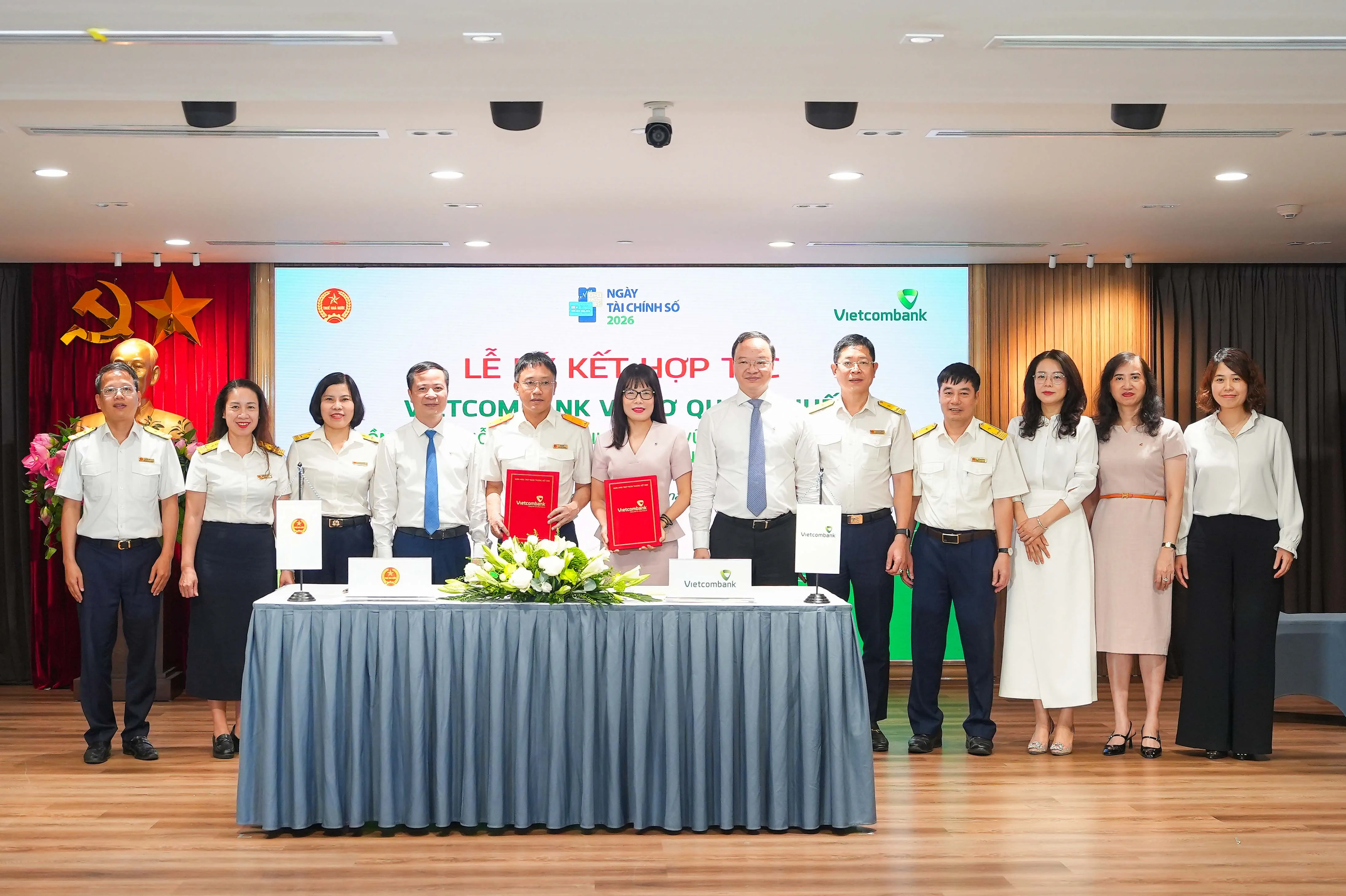 Ông Mai Sơn - Phó Cục Trưởng Cục Thuế (thứ 5, từ trái sang) và bà Đoàn Hồng Nhung - Thành viên Ban điều hành, Giám đốc Khối Bán lẻ Vietcombank (thứ 6, từ trái sang) thực hiện nghi thức ký kết và trao biên bản Thỏa thuận Hợp tác giữa Cục Thuế và Vietcombank dưới sự chứng kiến của đại diện lãnh đạo hai đơn vị