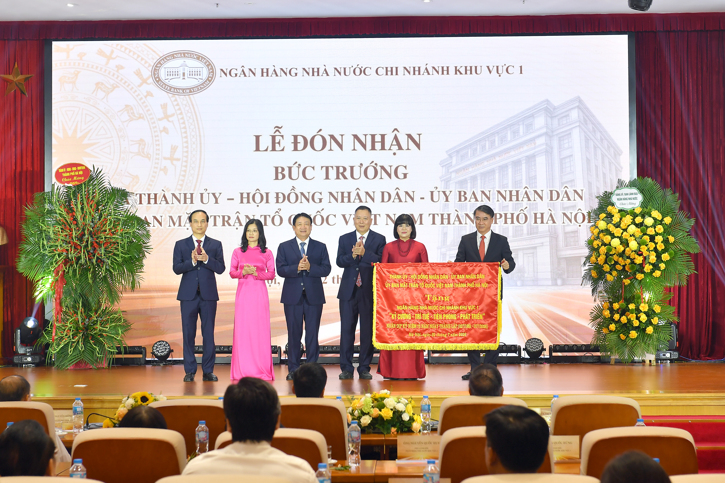 Đồng chí Nguyễn Xuân Lưu - Ủy viên Ban Thường vụ Thành ủy, Phó Chủ tịch Ủy ban nhân dân thành phố Hà Nội thay mặt lãnh đạo thành phố trao tặng bức trướng với tôn chỉ "Kỷ cương - Trí tuệ - Tiên phong - Phát triển" cho NHNN Khu vực 1