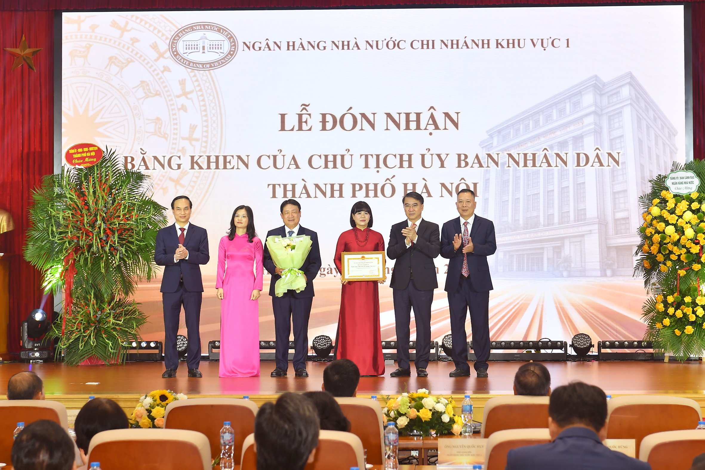 Đồng chí Nguyễn Xuân Lưu - Ủy viên Ban Thường vụ Thành ủy, Phó Chủ tịch Ủy ban nhân dân thành phố Hà Nội thay mặt Chủ tịch Ủy ban nhân dân thành phố Hà Nội trao tặng Bằng khen và tặng hoa cho NHNN Khu vực 1 đã có thành tích xuất sắc trong phong trào thi đua năm 2025