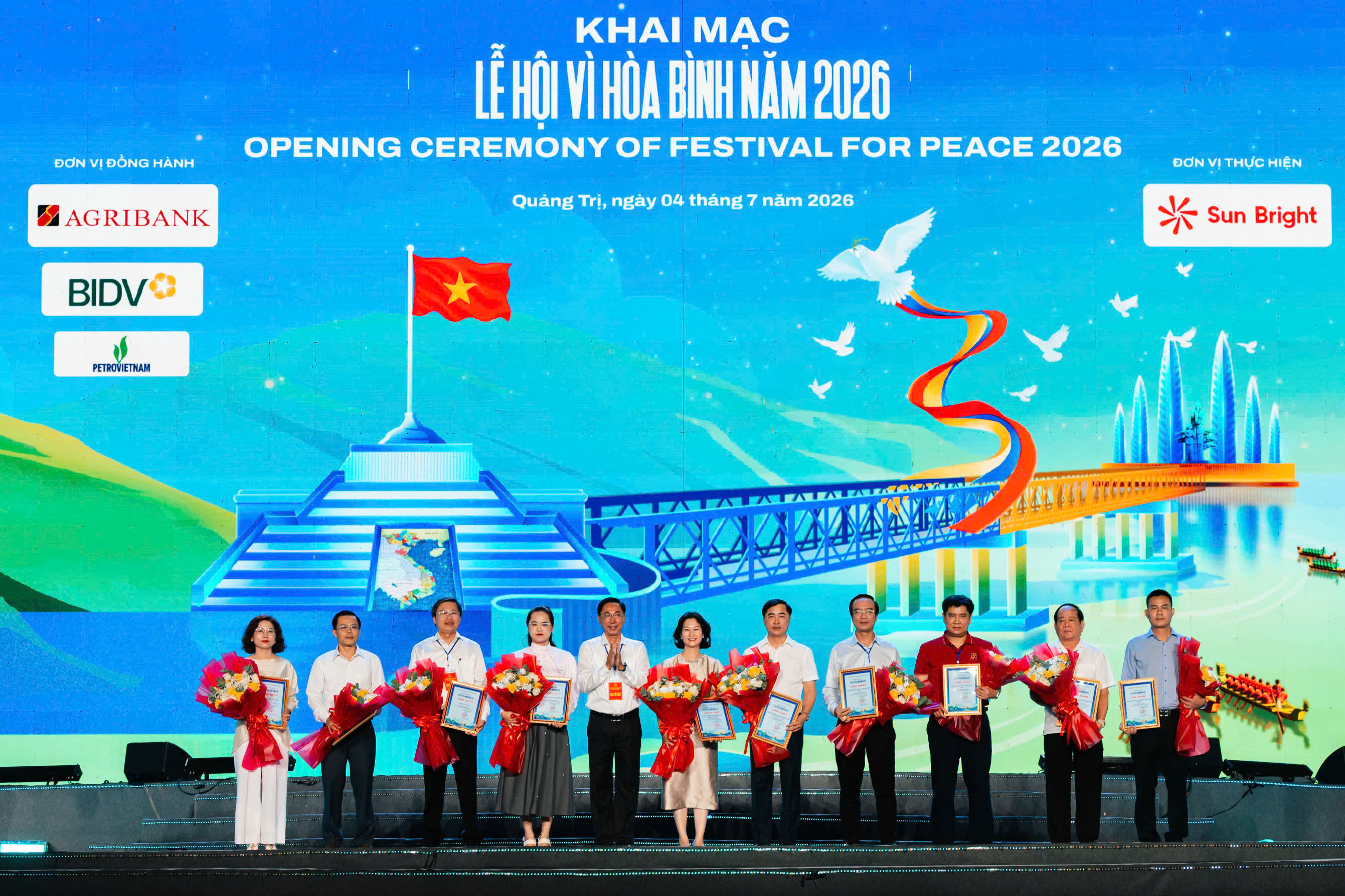 Ông Phan Hồng Hải - Giám đốc Agribank Chi nhánh Quảng Trị (thứ 3 từ phải sang) đại diện Agribank nhận hoa và biểu trưng tri ân từ Ban Tổ chức Lễ hội Vì Hòa bình năm 2026 tại Quảng Trị.
