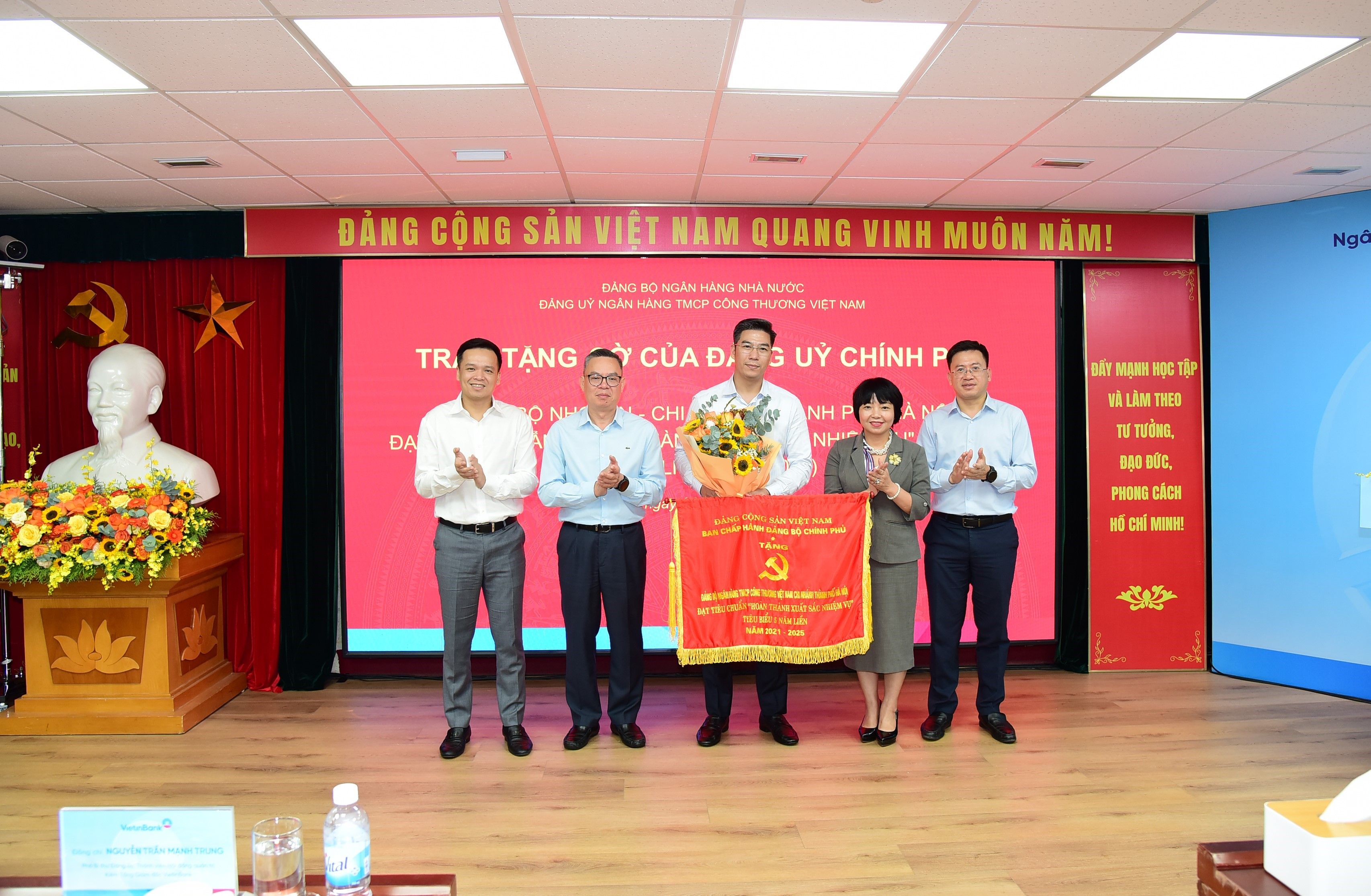 Ảnh: Đại diện Đảng bộ Chi nhánh Thành phố Hà Nội nhận Cờ của Đảng ủy Chính phủ cho đảng bộ “Hoàn thành xuất sắc nhiệm vụ” tiêu biểu 5 năm liền (2021 - 2025)