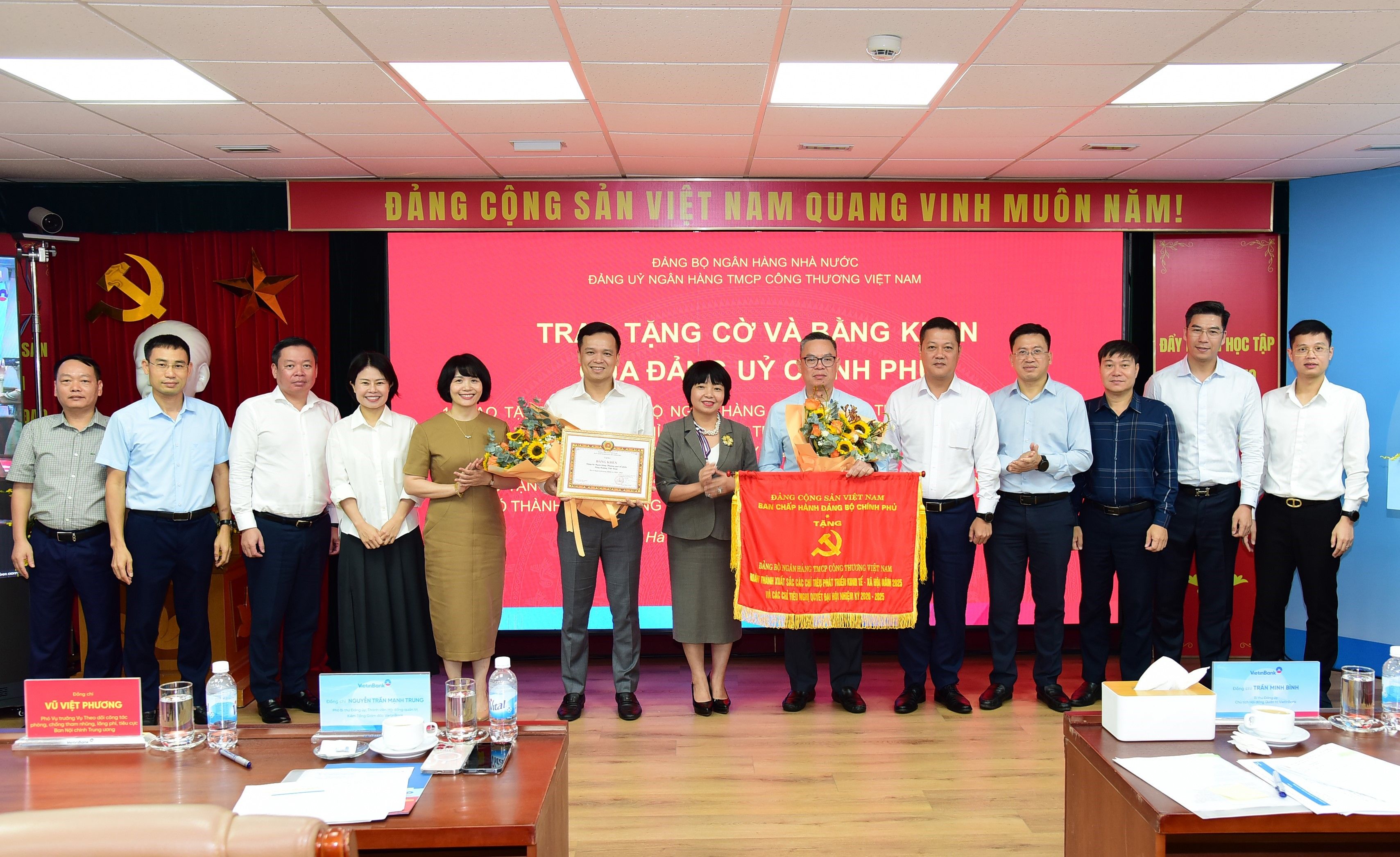 Ảnh: Đồng chí Lê Thị Mai Hương, Phó Bí thư chuyên trách Đảng ủy NHNN trao Cờ và Bằng khen của Đảng ủy Chính phủ cho Đảng bộ NHCTVN