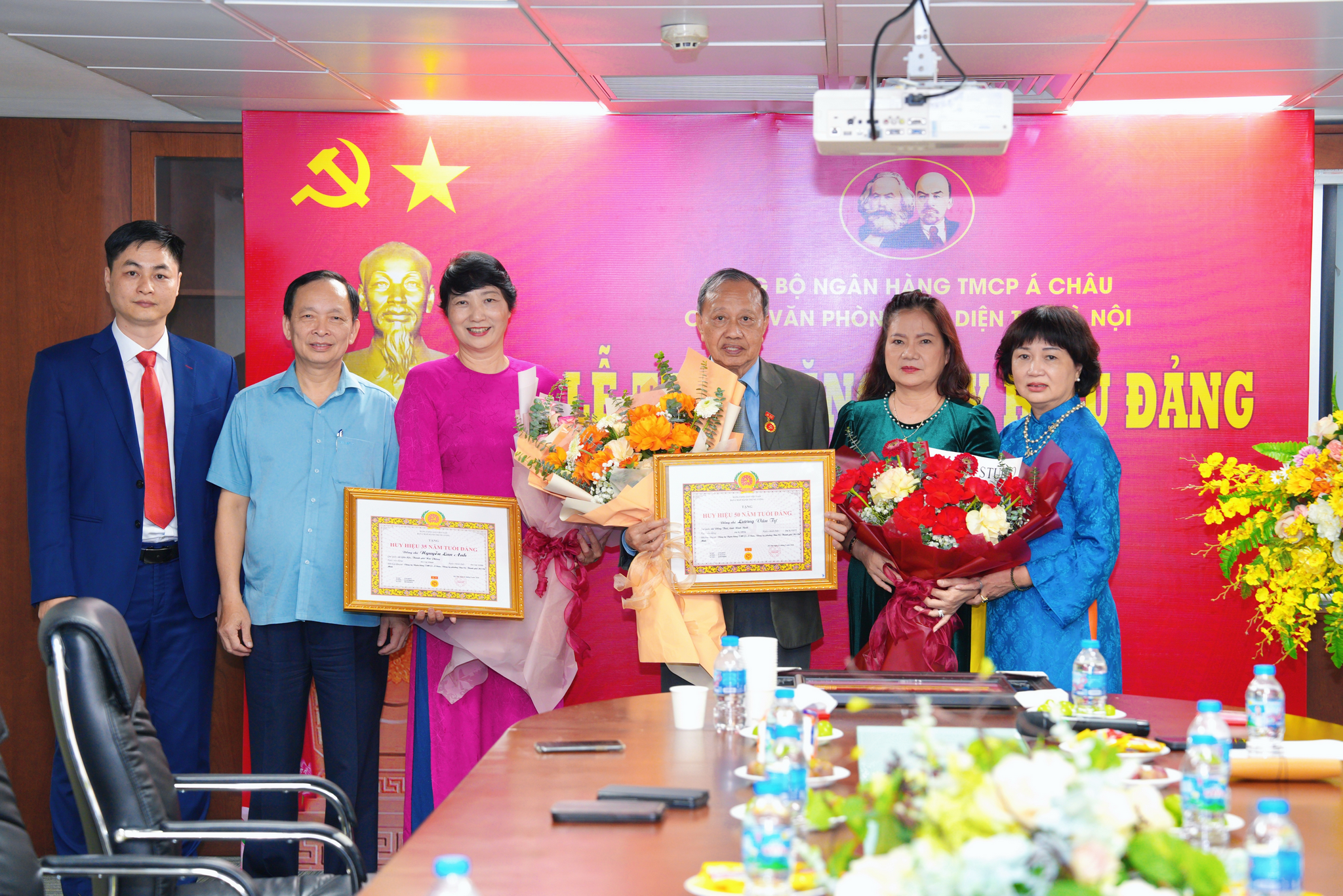 Đồng chí Đào Minh Tú, đồng chí Nguyễn Thị Tuyết Vân cùng các đại biểu tặng hoa chúc mừng đồng chí Lương Văn Tự, đồng chí Nguyễn Lan Anh được trao Huy hiệu Đảng và đồng chí Khương Thị Minh Hằng nhân dấu mốc 30 năm tuổi Đảng