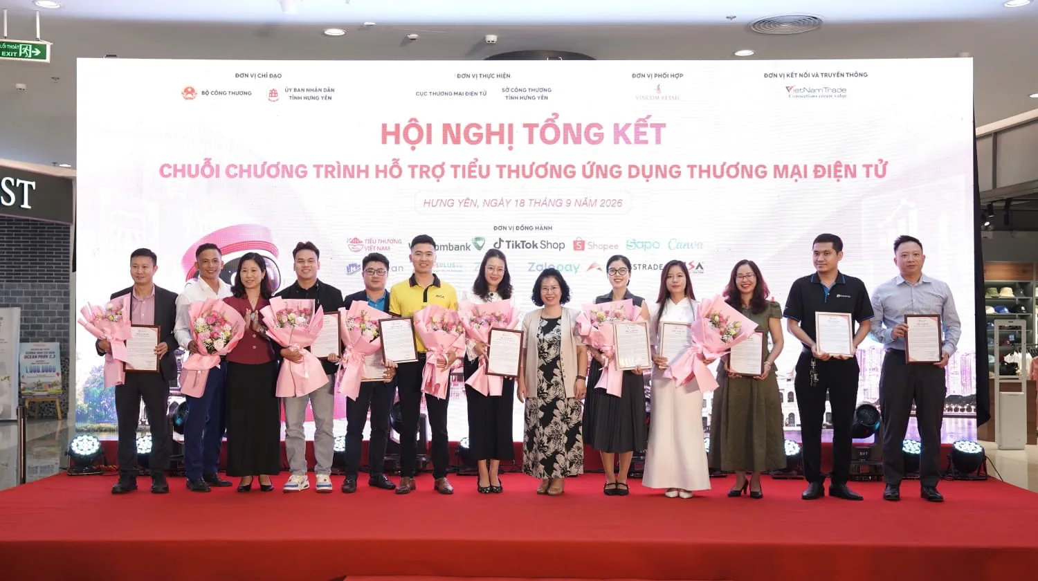 Đại diện Vietcombank, bà Lê Mai Nga - Trưởng phòng Quản lý kênh chi nhánh (thứ 7 từ trái sang) nhận hoa và thư cảm ơn từ Ban tổ chức, ghi nhận những đóng góp tích cực của ngân hàng trong hành trình đồng hành, hỗ trợ tiểu thương ứng dụng thương mại điện tử
