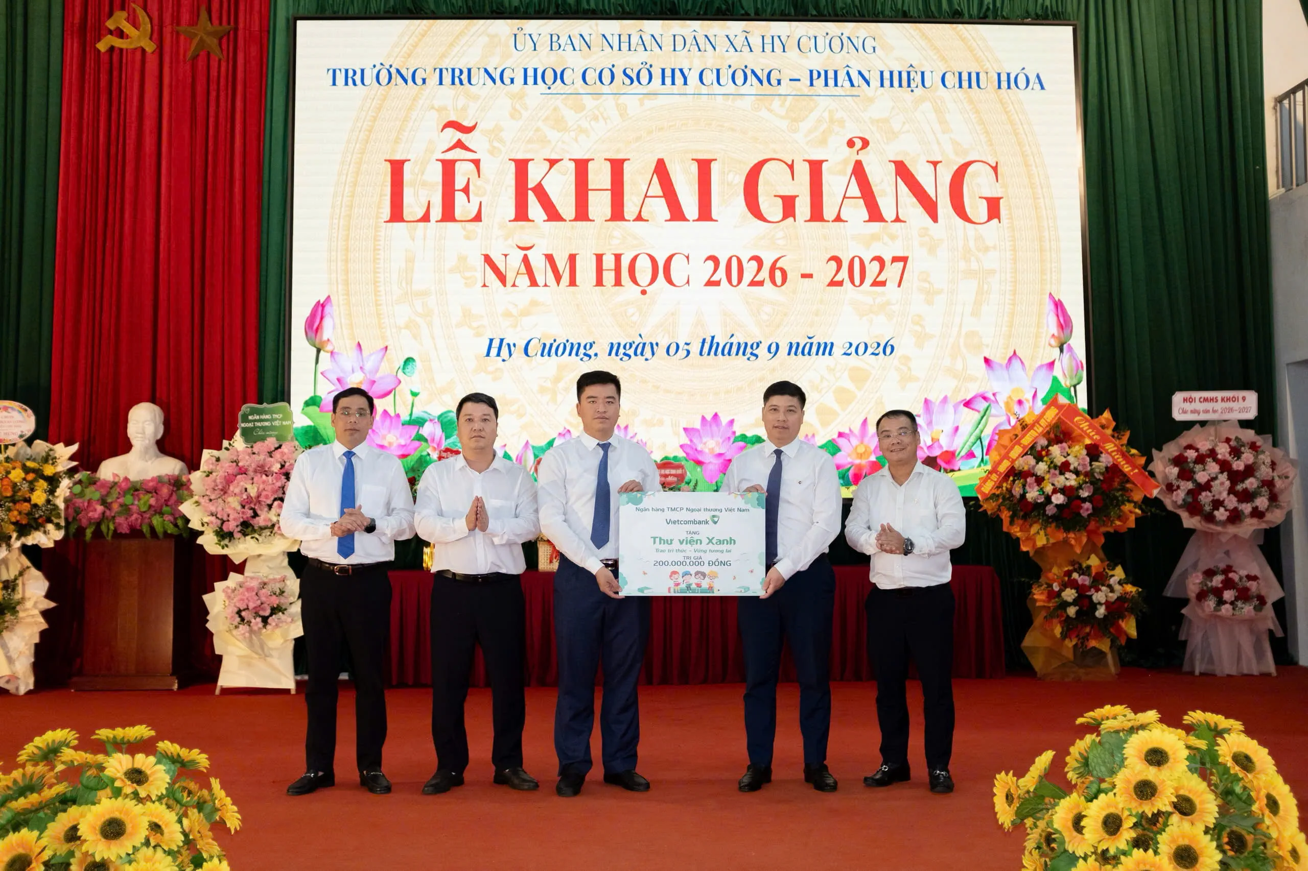 Đ/c Hồng Quang (thứ 2, từ phải sang) đại diện Vietcombank trao biển tượng trưng Thư viện Xanh cho Trường THCS Hy Cương