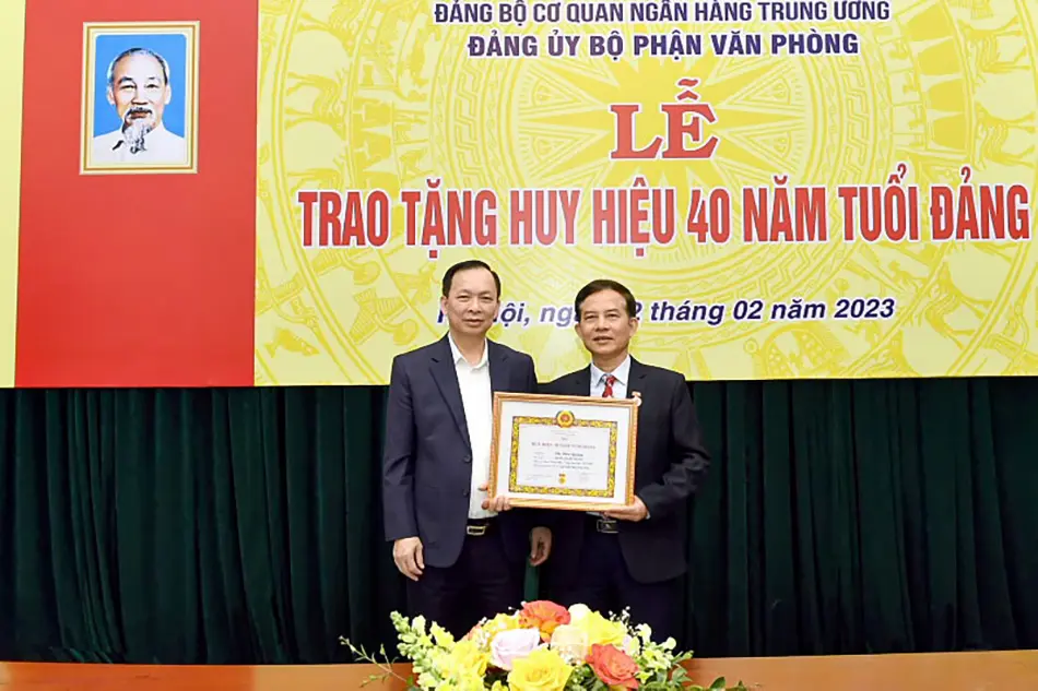Pho Thong doc thuong truc NHNN Dao Minh Tu trao Huy hieu 40 nam tuoi Dang cho dang vien Vu Van Quang